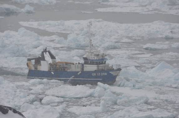 Barco abre seu caminho pelo gelo na costa de Ilulissat, na Groelândia
